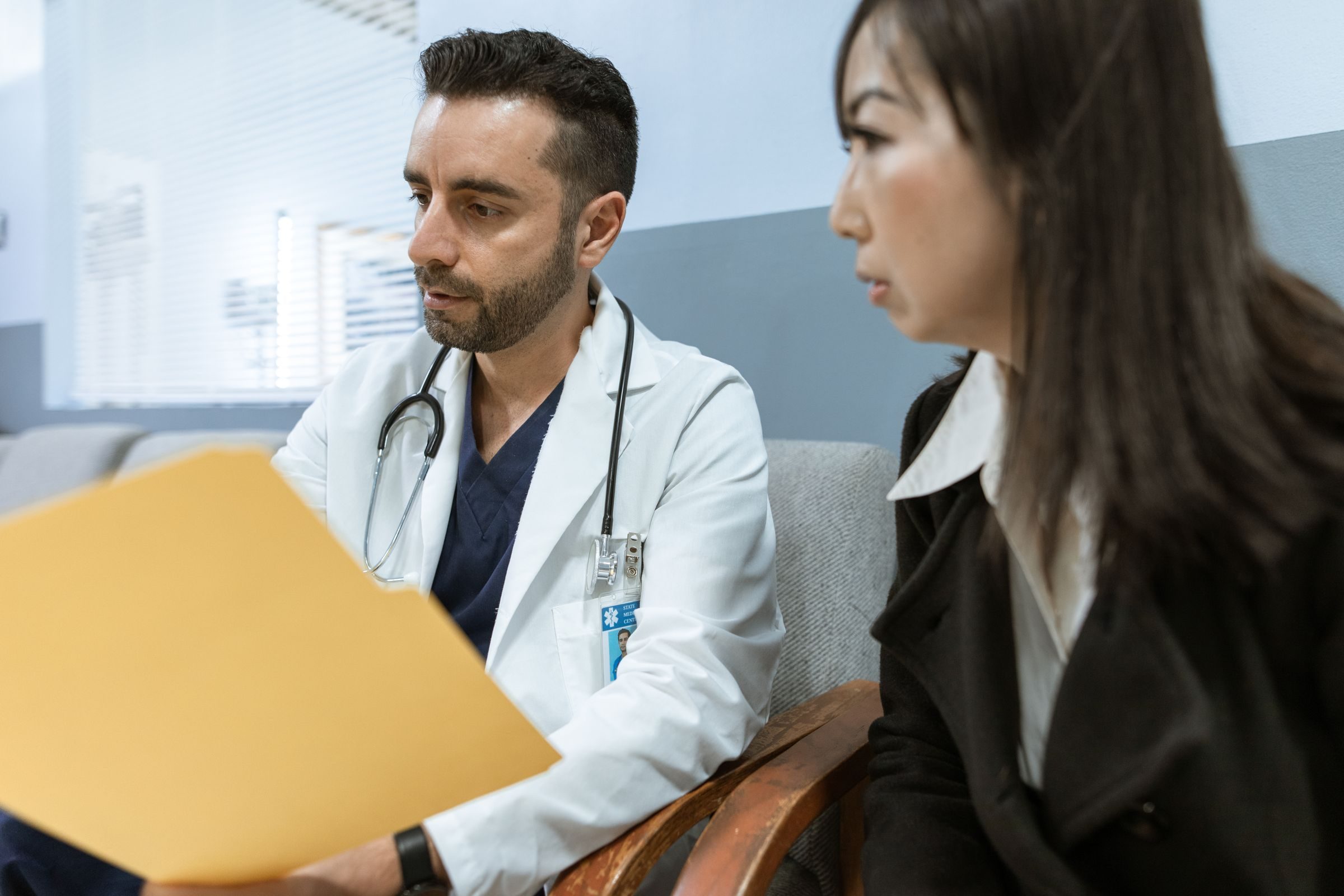 Médecin prenant des notes face à un patient lors d'une consultation